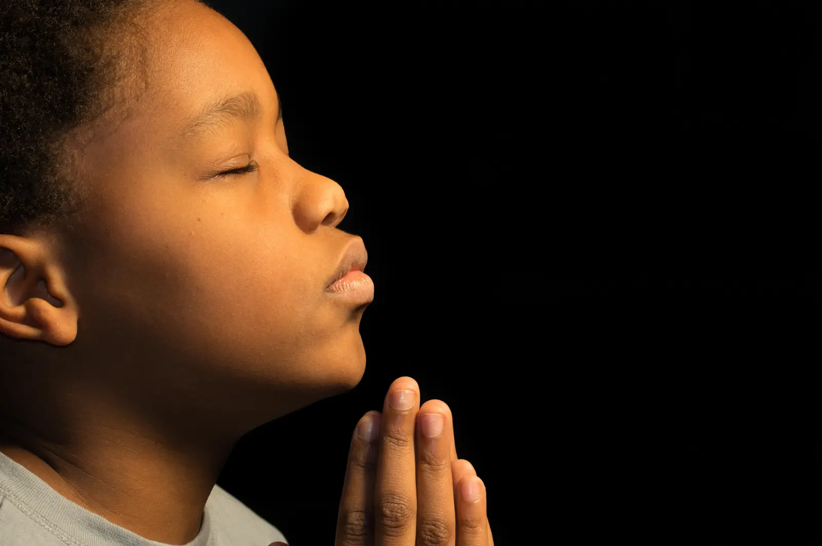 Manos de niños unidas en oración
