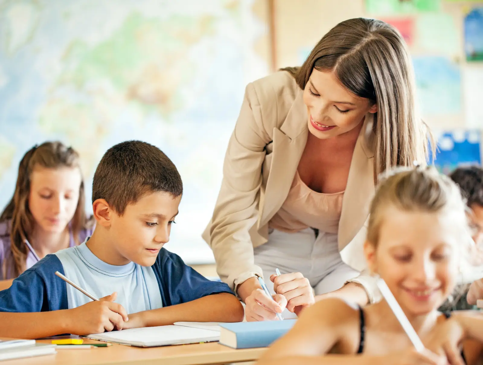 Profesora acompañando a dos alumnas en clase